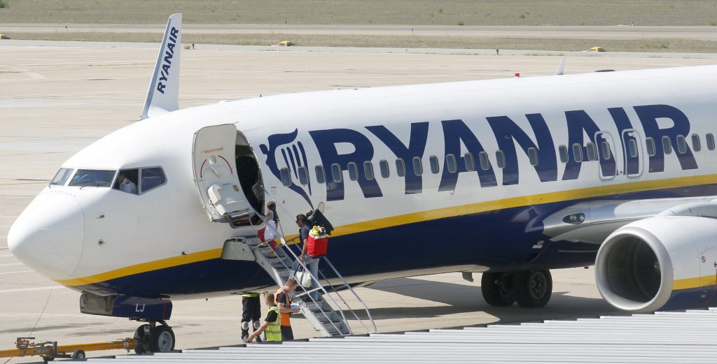 Passengers board a Ryanair plane parked at Girona airport